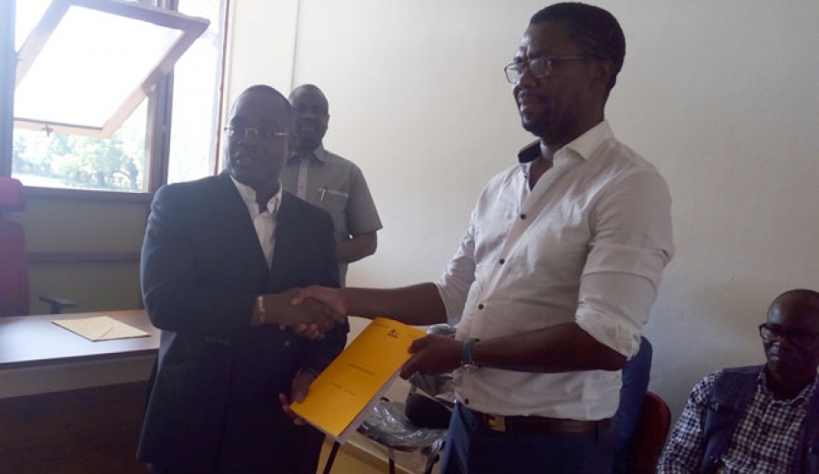 Pr. Justin koffi (en costume sombre), directeur général de l'ARRE, remet le premier récépissé d'entreposage à Hervé Gbadji, development business manager (en chemise blanche), représentant Martijn Versteeg..