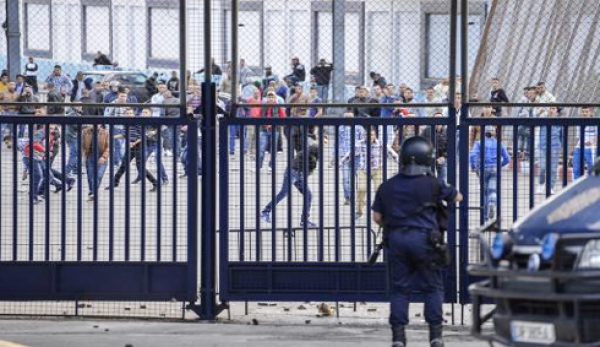 Des Marocains jettent des pierres contre la frontière grillagée qui sépare le Maroc de l'enclave espagnole de Melilla, en octobre 2012 à Beni-Enzar