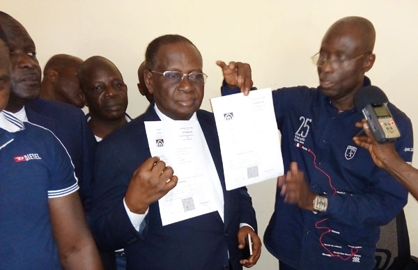 Doumbia Tidiane à droite présente des extraits d'actes de naissance avec des QR code au maire Tahi Glahou Jean à gauche.
