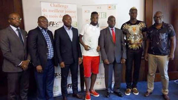 Ibrahim Ouattara (culotte rouge) et Aristide Bancé (cheveux teints en jaune) posent avec les responsables de la CIE et ceux de l'AFI.