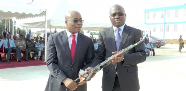 Le président de la ComNat (à gauche) remettant une arme symbolique au représentant du CNS, Agoh Christian.
