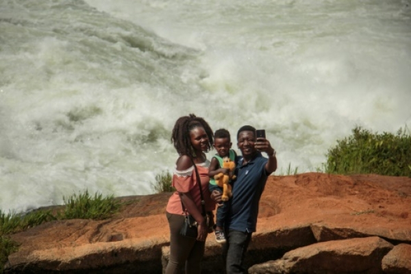Une famille se prend en selfie avec le Nil en arrière-plan à Jinja, en Ouganda, le 25 janvier 2019 | AFP | Sumy SADURNI