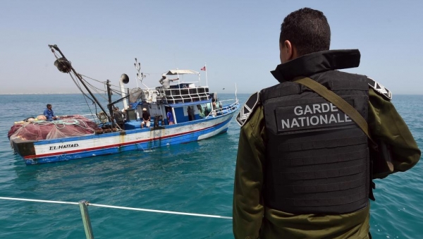 Un membre de la garde nationale tunisienne contrôle un bateau de pêcheur au large des côtes tunisiennes (image d'illustration).