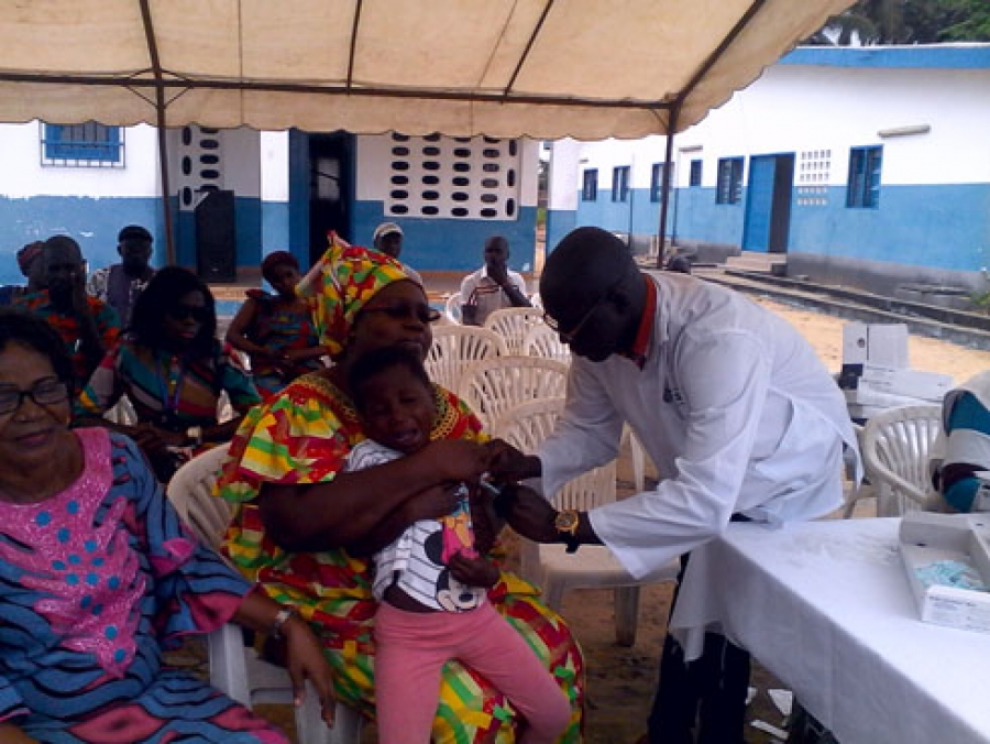  La Présidnte de l'Ong N'Klo  Bakan, Dagri Généviève aidant à faire vacciner un enfant