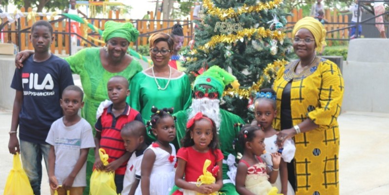 Des enfants, heureux de recevoir des jouets, posent avec la présidente de l’Asoded-Ci (à droite). (DR)