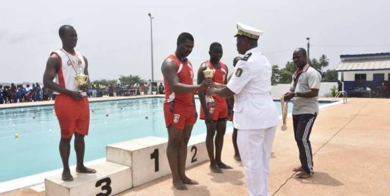 Le contre-amiral, N’Guessan Kouamé Célestin, chef d’état-major de la marine nationale récompensant des vainqueurs de ces journées sportives. 

PHOTO: DR