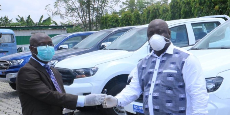 Le directeur de l'Agence Côte d'Ivoire Pme (à droite) recevant les clés des voitures des mains de Gilbert Ekpini, coordonnateur de la cellule de coordination du Prici.(DR)