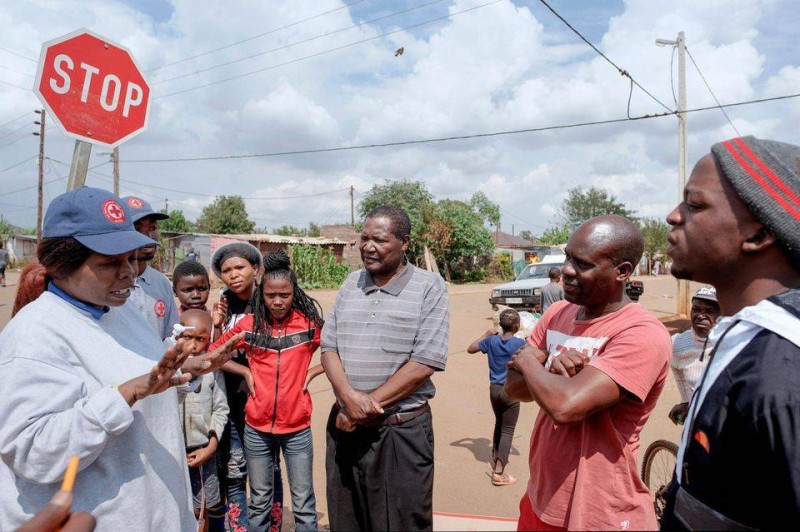 Des membres de la Croix-Rouge donnent des conseils de prévention sanitaire pour tenter de contenir l'épidémie de Covid-&9, dans le campement de Protea à Soweto, le 23 mars. (Photo Luca Sola. AFP)