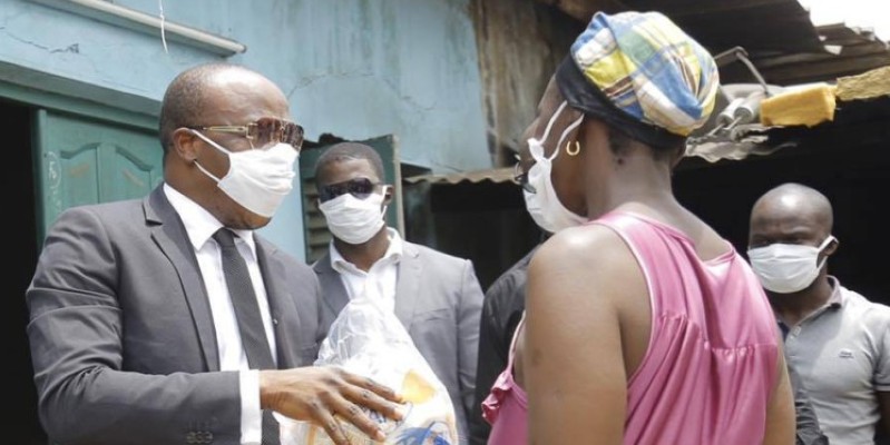 Traoré Salif dit A'Salfo remettant un kit à une femme dans la commune d'Abobo. (Sercom Gaou Productions)