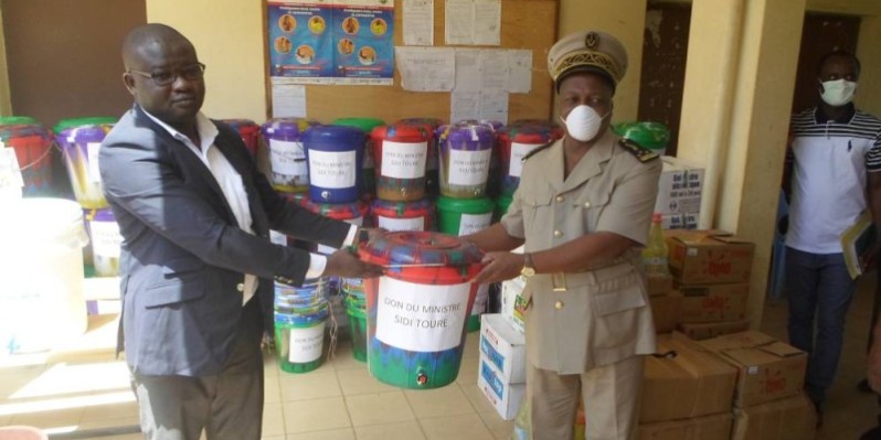 Ali Diabaté (à gauche), représentant le ministre Sidi Touré, remet symboliquement le kit sanitaire à Jules Gouessé, préfet de Béoumi. (CHARLES KAZONI)