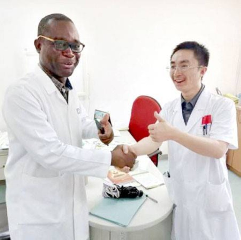 Un membre de l'équipe d'aide médicale chinoise au Burkina Faso prend une photo avec un médecin spécialisé dans les maladies respiratoires de l'hôpital de Tengandogo, au Burkina Faso, le 30 janvier 2020. (Photo fournie par l'équipe d'aide médicale chinoise au Burkina Faso)