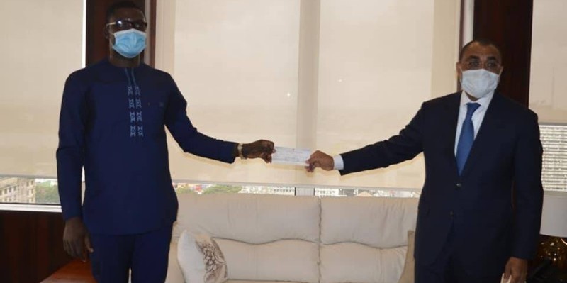 Le ministre de l’Economie et des finances a reçu le chèque des mains du responsable administratif du groupe Ebomaf, Sawadogo Abdoulaye. (DR)