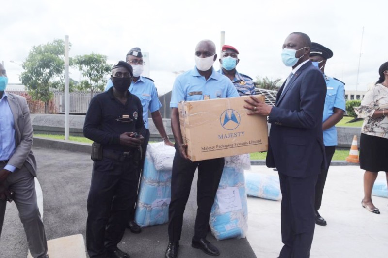 Remise symbolique des cache-nez aux forces de l’ordre par le ministre des Transports, Amadou Koné (à droite).