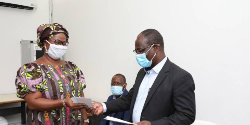 Venance Konan remet un bon d'achat à Aly Kouamé Colette épse Yao, la présidente de l'Association des femmes de Fraternité Matin. (Photo: Bosson Honoré)