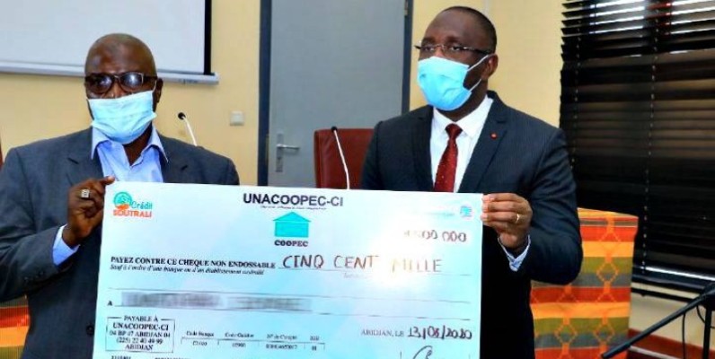 Diarrassouba Souleymane, ministre du Commerce remettant un chèque à un commerçant. (DR)