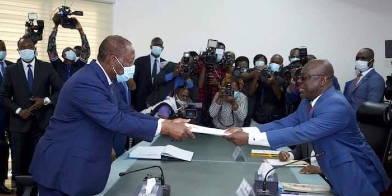 Le Chef de l'Etat, Alassane Ouattara, à gauche, remettant ses dossiers. (Dr)