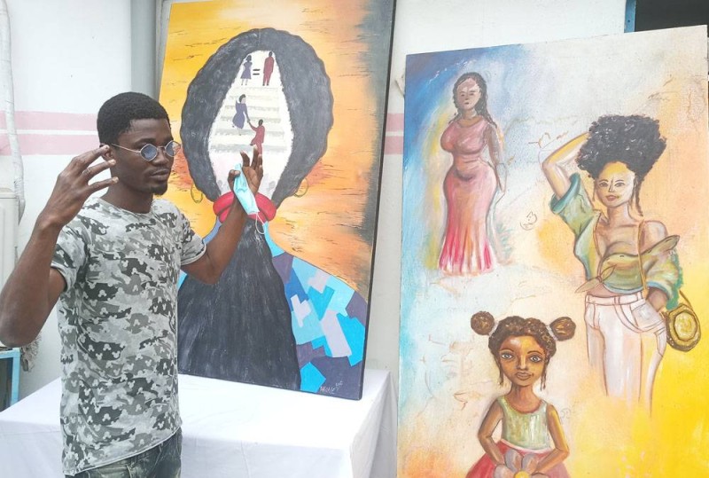 Le jeune peintre Adjé Frédéric Anderson présentant son oeuvre (Ph: Salif D. CHEICKNA)