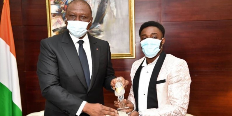 Le Premier ministre Hamed Bakayoko recevant le trophée d'Arthur Gué. (DR)