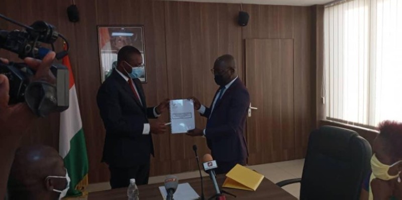 Le ministre Sidi Touré (à gauche) recevant le rapport des mains de Vamara Coulibaly. 