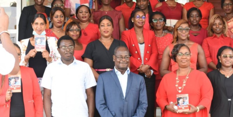 L’auteur (en blanc) pose avec des membres de l’Association des femmes de Fraternité Matin (en rouge) et leur directeur général (en costume). (Photo : Ange Kumassi)