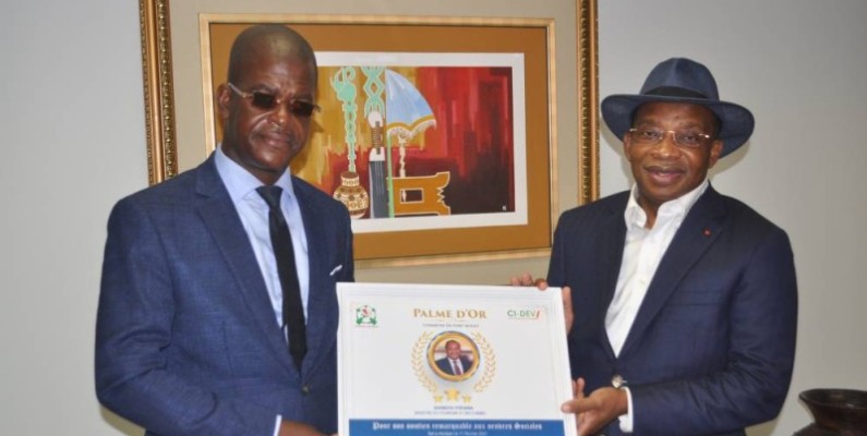 Le ministre Siandou Fofana (à droite) recevant sa distinction des mains de Aimond William.(DR)