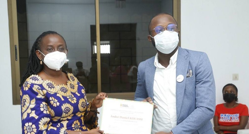 Mme Bintou APPIA remettant un certificat à un startuper Orange Corner