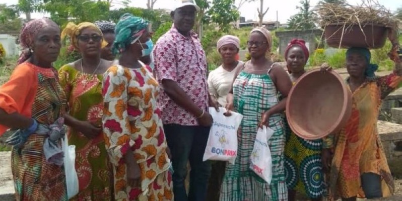 Le président de l'Ong distribuant des dons à des femmes bénévoles opérant dans le cimetière de Yopougon (DR)