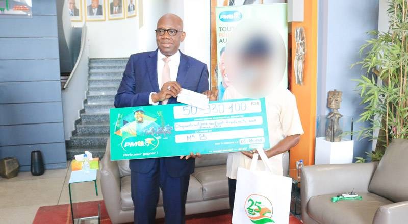 Le Directeur général de la Lonaci remettant le chèque au gagnant. (Photo : DR)
