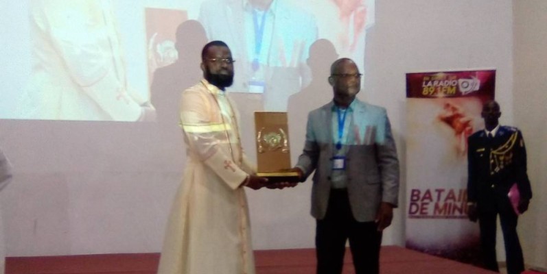 L’évêque général Jean Koné (en soutane) recevant son prix des mains du président de l’observateur. (Photo : Franck YEO)