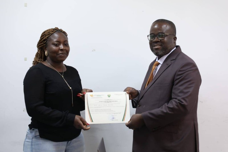 Le directeur de la vie associative et du renforcement des capacités des jeunes, Constant Koffi remettant un diplôme de participation à une participante. (DR)