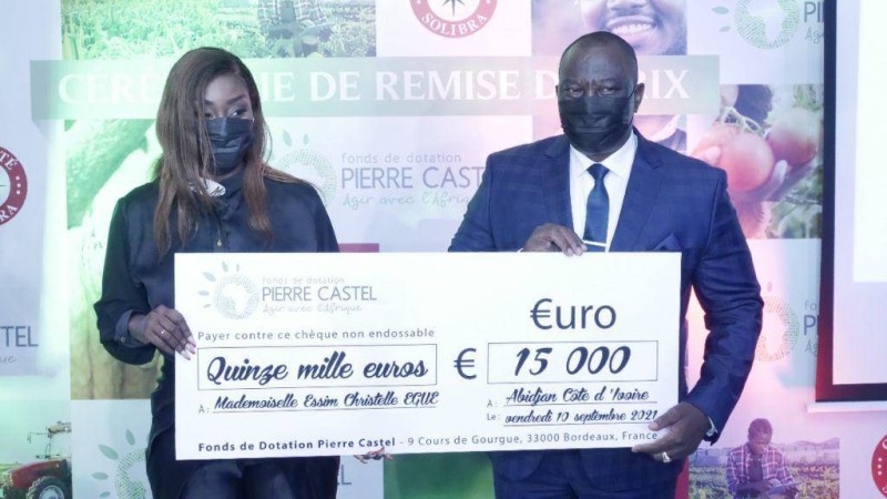 Mlle Christelle Essim Egue recevant son chèque des mains du ministre Adjoumani