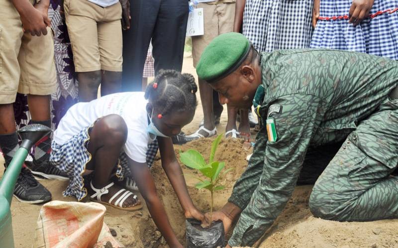 Un agent des Eaux et Forêts plantant un arbre avec une écolière. (DR)