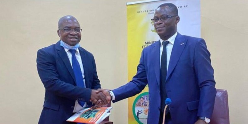 Allou Saraka Koffi André, Dg de l’aménagement du territoire, du développement régional et local (à droite) remettant le Manuel de planification participative à un participant. (DR)