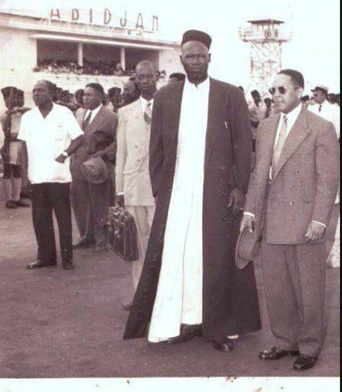 Yacouba Sylla en coiffe et manteau et l’ancien gouverneur colonial Guy Nairay
