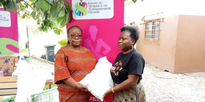 Mme Sandrine Roland (à droite) remettant un kit alimentaire Mme Félicité kouadio, directrice du centre Pavios. ( Franck YEO)