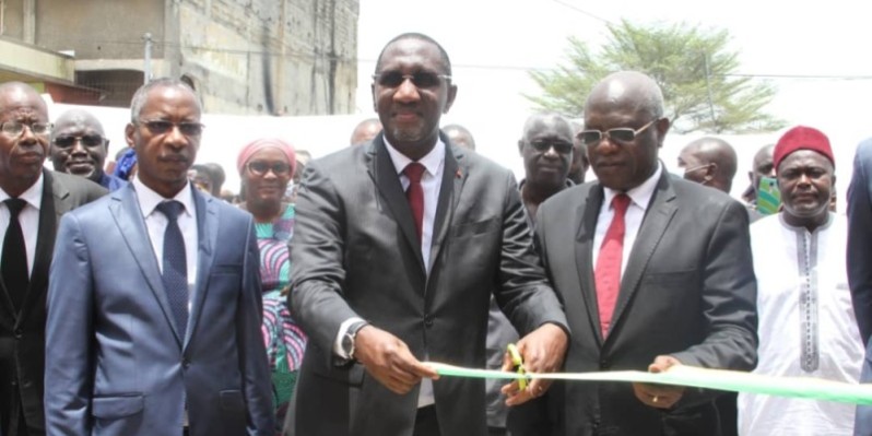 Le ministre Souleymane Diarrassouba coupant le ruban lors de l'inauguration du nouveau marché en présence des autorités et des riverains. (Ph: Dr)