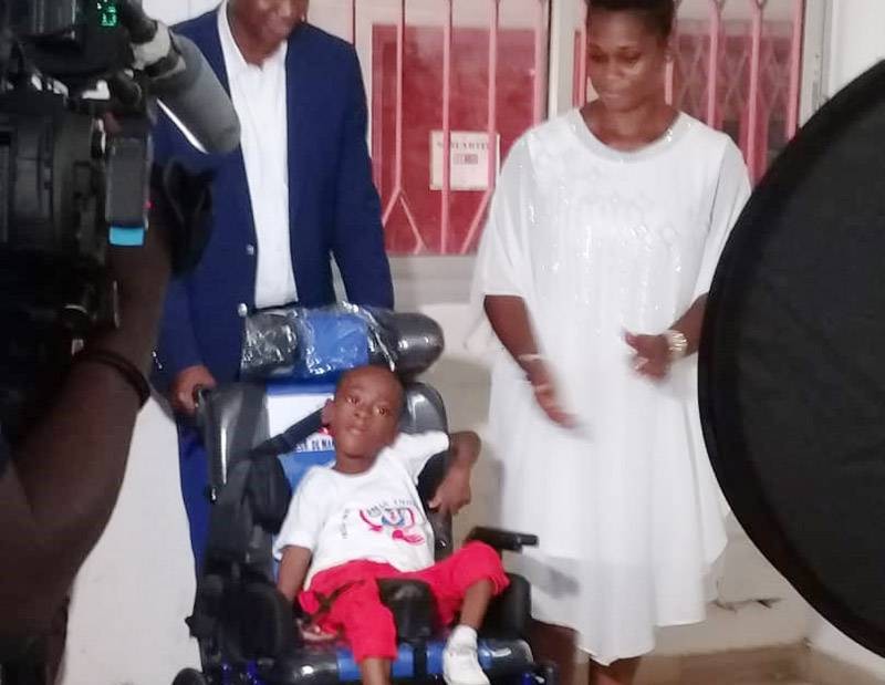 Un enfant IMC dans son fauteuil à la grande joie de parents et donateurs. (Ph: Dr)
