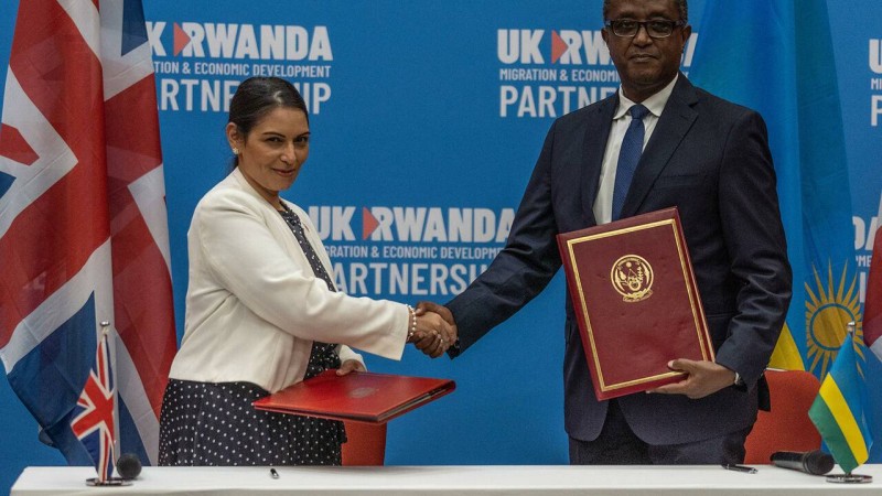 British Home Secretary Priti Patel (L), and Rwandan Minister of Foreign Affairs and International Cooperation Vincent Biruta, shake hands after signing an agreement at Kigali Convention Center, Kigali, Rwanda on April 14, 2022. - An agreement was finally announced Thursday with Rwanda, where British Home Secretary Priti Patel visited. Asylum seekers arriving in the UK will be sent to Rwanda, under a controversial deal announced Thursday with which Boris Johnson's government hopes to deter record-breaking illegal Channel crossings. London will initially finance the device to the tune of 120 million pounds sterling (144 million euros). (Photo by Simon WOHLFAHRT / AFP)