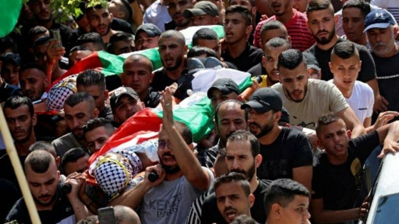 Palestinian mourners carry the body of Raed Abu Seif (bottom) and Saleh Ammar (top), two of four Palestinians killed in clashes with Israeli security forces earlier in the day, during their funeral in the Jenin refugee camp in the north of the occupied West Bank on August 16, 2021. - At least four Palestinians were killed in clashes with Israeli security forces at Jenin refugee camp in the West Bank, an Israeli official and the Palestinian health ministry said. Deadly clashes have been frequent in Jenin and the flashpoint West Bank town of Beita since May, when dozens of Israeli families arrived and began constructing the wildcat settlement of Eviatar. (Photo by JAAFAR ASHTIYEH / AFP)