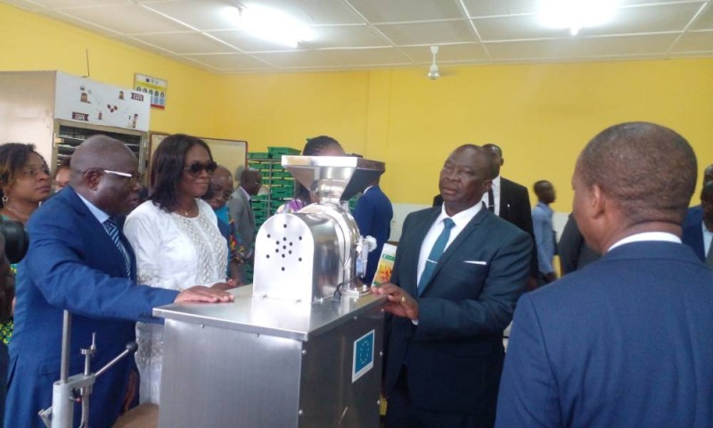 Le ministre Kobénan Kouassi Adjoumani devant la machine de torréfaction, lors de la visite de l'un des laboratoires spécialisés