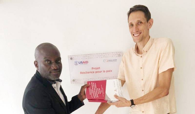 Monsieur Victorien N’tayé recevant une série de six (6) rapports d’enquête et d’études des mains de Monsieur Mirko Hoff, Chef de Projet Adjoint d’Equal Access International. (Ph: Dr)