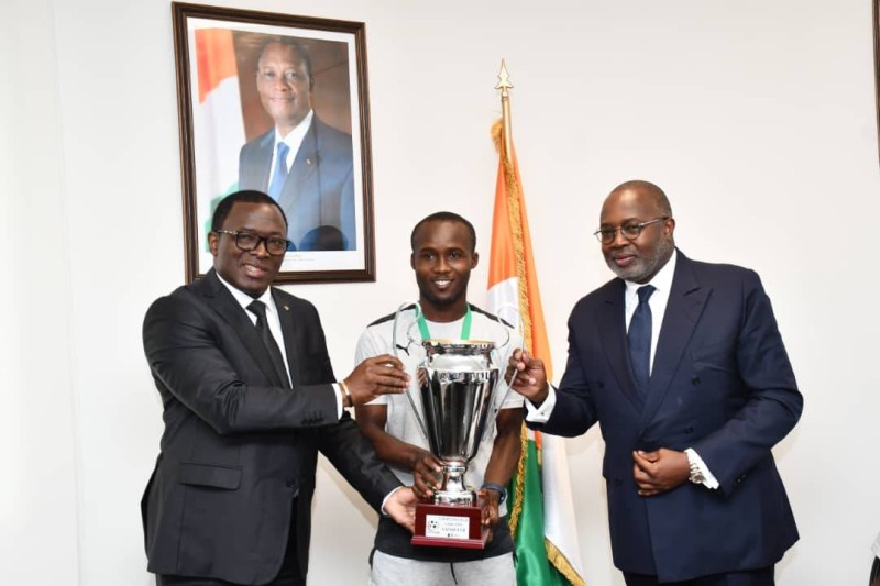 Le capitaine des Éléphanteaux remettant le trophée au ministre des Sports. (Ph: Dr)