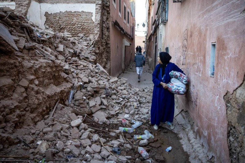 A woman looks at the rubble of a building in the earthquake-damaged old city in Marrakesh on September 9, 2023. A powerful earthquake that shook Morocco late September 8 killed more than 600 people, interior ministry figures showed, sending terrified residents fleeing their homes in the middle of the night. (Photo by FADEL SENNA / AFP)
