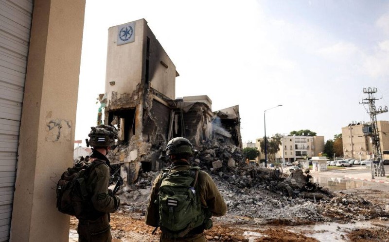 Israeli soldiers look at the remains of a police station which was the site of a battle following a mass infiltration by Hamas gunmen from the Gaza Strip, in Sderot, southern Israel October 8, 2023. REUTERS/Ronen Zvulun