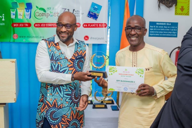 Le président de "Moi Jeu Tri" Edem d'Almeida remettant à Daouda Sanogo, Directeur de L'EPP Blockauss 2, le prix de la meilleure école partenaire. (dr)