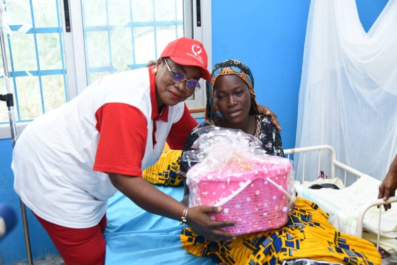 La présidente de l'ONG offre un kit sanitaire à une maman. (DR)