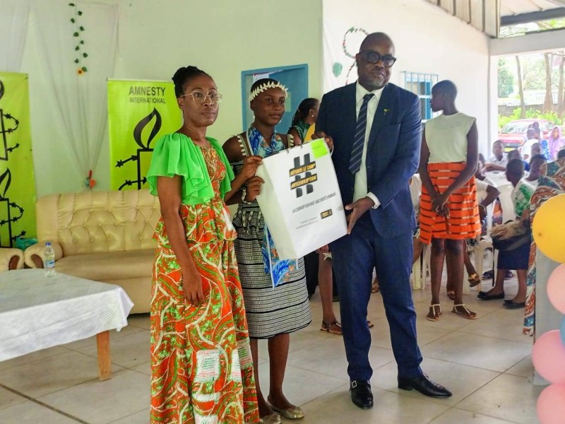Le directeur exécutif d’Amnesty Côte d’Ivoire remettant un kit à une lycéenne. (DR)