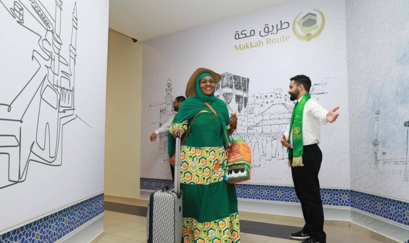 Une pélérines ivorienne dans l'espace saoudien du Terminal 2 se faisant guider par un fonctionnaire saoudien