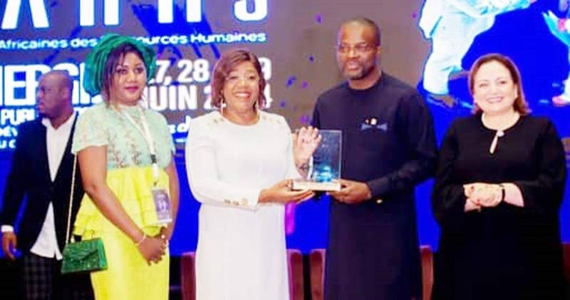 Euphrasie Kouassi Yao (en robe blanche) recevant un trophée des mains du responsable de l'Afdip. (Ph: Dr)