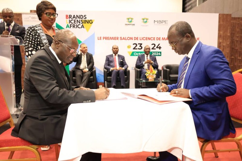 Le président de la Cci-ci, Faman Touré (à gauche) et le directeur général de l'Oipi, Dr Koffi Assandé, paraphant la convention de partenariat. (Franck YEO)